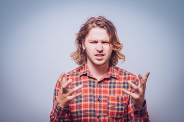 portrait of pissed off young adult man, hands in air