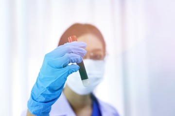 Obraz premium Scientist holding Coronavirus covid-19 infected blood sample tube DNA testing of the blood in the laboratory with blood sample collection tubes and syringe Coronavirus Covid-19 vaccine research.