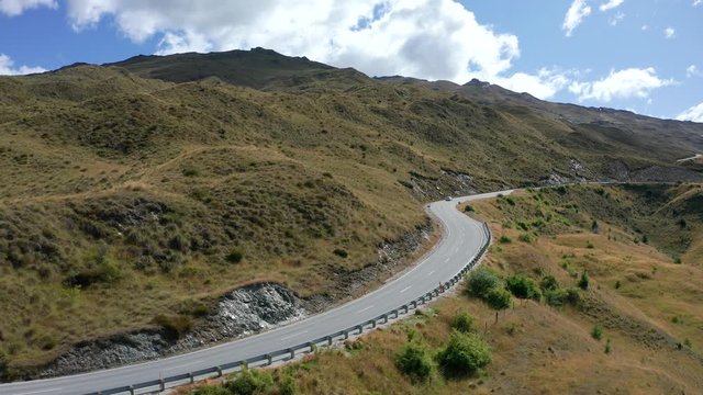 Winding road in mountains of The Coronet Peak and Skippers Road entrance. Arrowtown in the background.