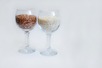 rice and buckwheat groats stand in a wine glass on a white background