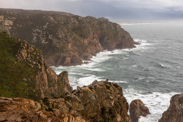 Rocks on the shore of ocean near the Cape of Rock in Portugal. The most Western point of Europe