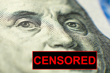 A closed mouth with the sign CENSORED on a portrait of Benjamin Franklin from a hundred-dollar bill.