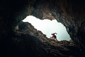 Runner silhouette, man running in rocky mountains. Unusual trail run sport photo