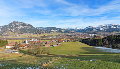 View of Sonthofen with snow-covered mountains and green pastures. Allgäu Alps, Bavaria, Germany