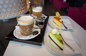 Two Irish coffee and two cheesecakes on a table