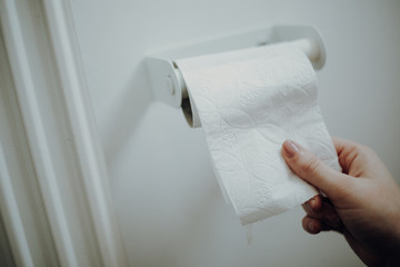 Woman grabbing toilet paper