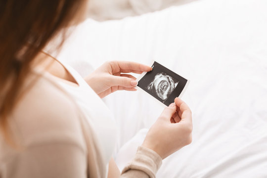 Pregnant woman caressing her belly with sonography