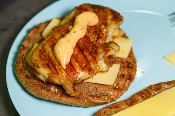 homemade hamburger with chicken, sauce and cheese fried on an electric grill