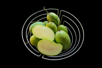 Group of fresh green mangoes on a black background.