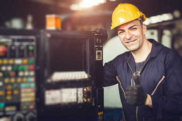 Happy worker, portrait handsome labor thumb signal with safety suit at machine control panel in...