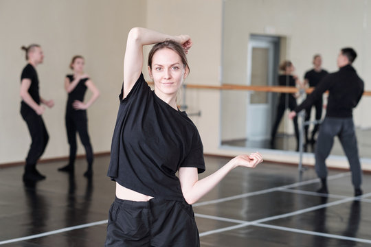 Pretty young student of modern ballet dancing course in black activewear