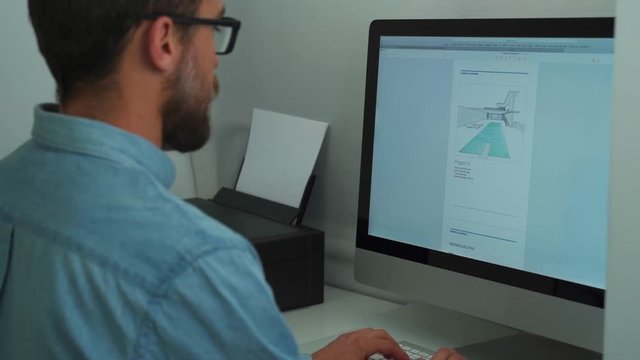 Businessman with a long beard and glasses working on his computer