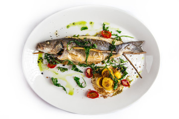 Sea bass fish cooked at home on a white plate, top view, horizontal