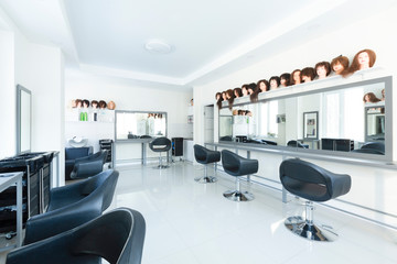 Variety of hairstyles on mannequins in hairdressing salon