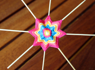 Wicker mandala made of blue yarn on wooden toothpicks. Flower  or star pattern.