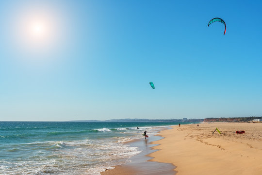 The athlete practices kate board surfing the sea on the waves. Summer in Portugal Algarve.