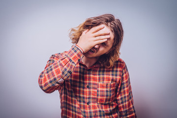  man covers his face by hand