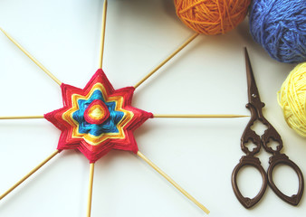 Wicker mandala made of blue yarn on wooden toothpicks. Flower  or star pattern.