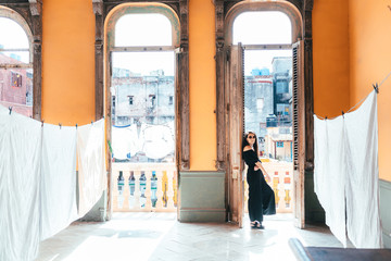 A girl in black overalls stands at the exit to the balcony