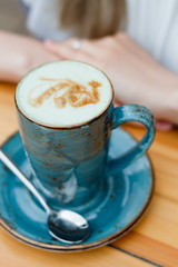 cup of coffee with cream on wooden background