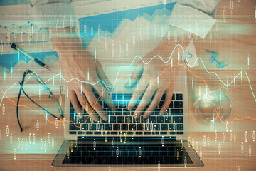 Double exposure of market chart with man working on computer on background. Concept of financial analysis.