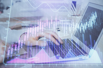 Double exposure of stock market graph with man working on laptop on background. Concept of financial analysis.