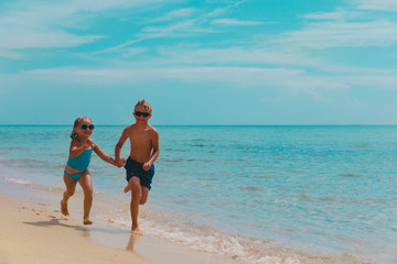 Fototapeta premium happy girl and boy run and play with water at beach