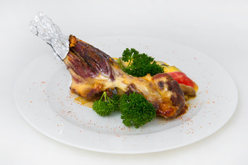 Baked meat on the coals with melted cheese and tomatoes. Garnished with a sprig of curly parsley