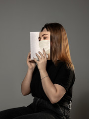 Happy world book day 2020, be safe and read to become someone else - woman covering face with book...