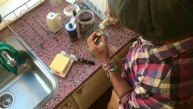 Top view of person making bulletproof coffee in kitchen