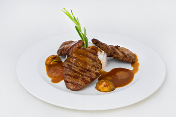 Grilled beef patties, a slide of white rice, egg yolks, red sauce, a sprig of rosemary for decoration