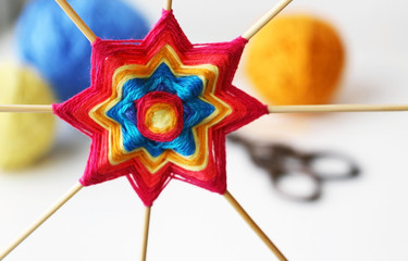 Wicker mandala made of blue yarn on wooden toothpicks. Flower  or star pattern.