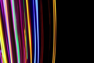 Pink and multi color light painting photography, long exposure photo of gold, pink, green and blue streaks of vibrant color against a black background