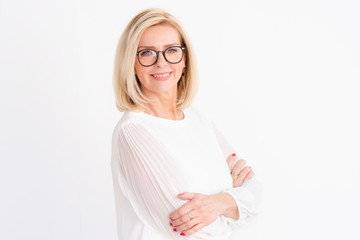 Attractive senior woman studio portrait while looking at camera and smiling