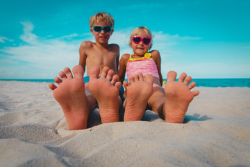 little boy and girl play with sand on beach