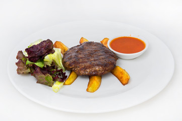 Grilled cutlet with slices of french fries, as well as cabbage salad and tomato sauce