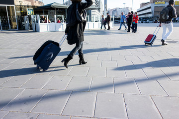 Obraz premium people dragging a travel suitcase