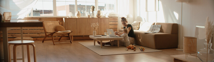 Caucasian mother working from home, having a work video call, daughter playing nearby. Stay home,...