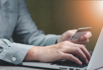 Close up hand business man shopping by laptop and using credit card for paying working and shopping at home concept