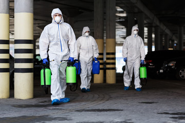 Men in virus protective suits planning to disinfecting city with chemicals