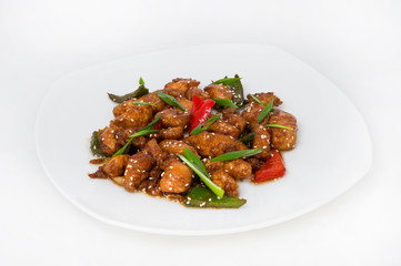 Braised chicken slices in a sauce with colored sweet pepper and slices of green onions for decoration