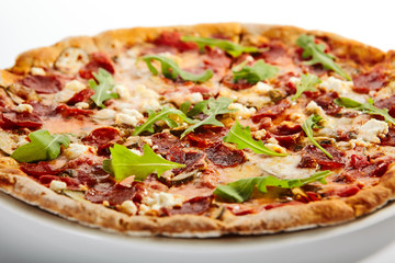 Pepperoni pizza slices with arugula on plate