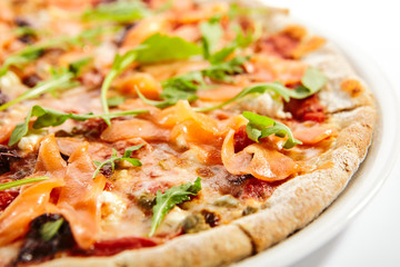 Sliced pizza with salmon, calamata olives and sun dried tomatoes