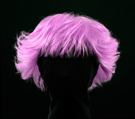 Pink hair wig isolated on black background