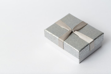 Small silver gift box with a silver bow
