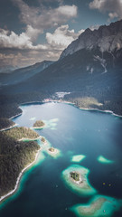 Aerial view shot by a drone of the Eibsee with islands and trees on the lake shore