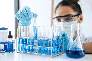 Scientist or medical in lab working in biotechnological laboratory using equipment for research with mixing reagents in glass flask in clinical laboratory