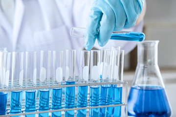 Biochemistry laboratory research, Scientist or medical in lab coat holding test tube with using...