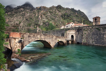 Fototapeta na wymiar Kotor, Montenegro. Old stone bridge across Scurda river and gate to old town