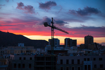 Buildings under construction with crane at sunset